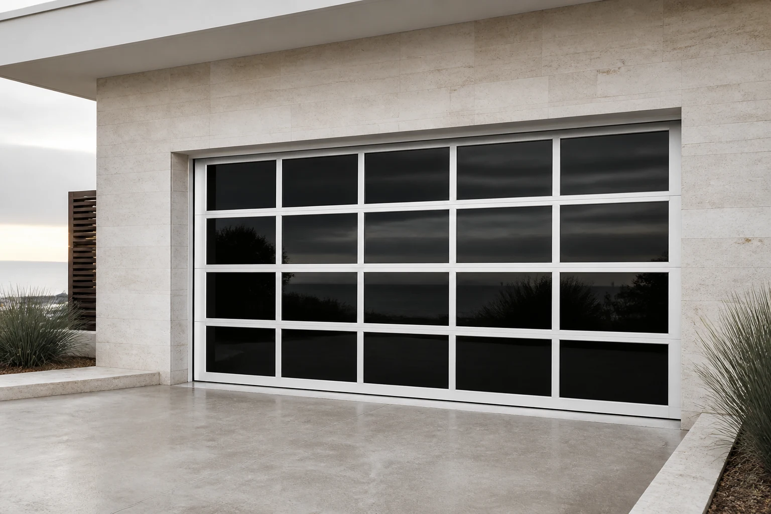 Illustrative application scene of a white-frame RGNL frameless mirror garage door with dark reflective glass panels in a coastal courtyard