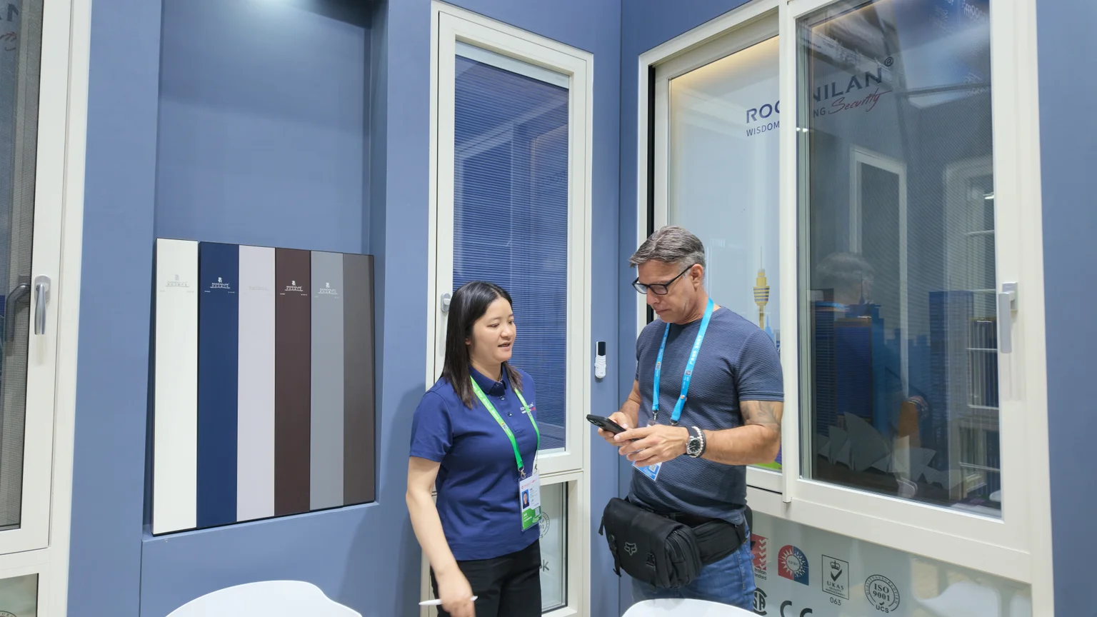 Window and finish displays beside a booth conversation at Rogenilan in April 2026